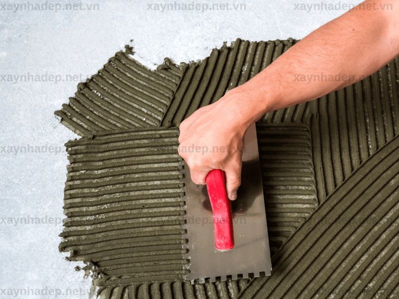 Bước 4 – Trét keo bằng bay răng cưa để tạo lớp liên kết đều dưới gạch